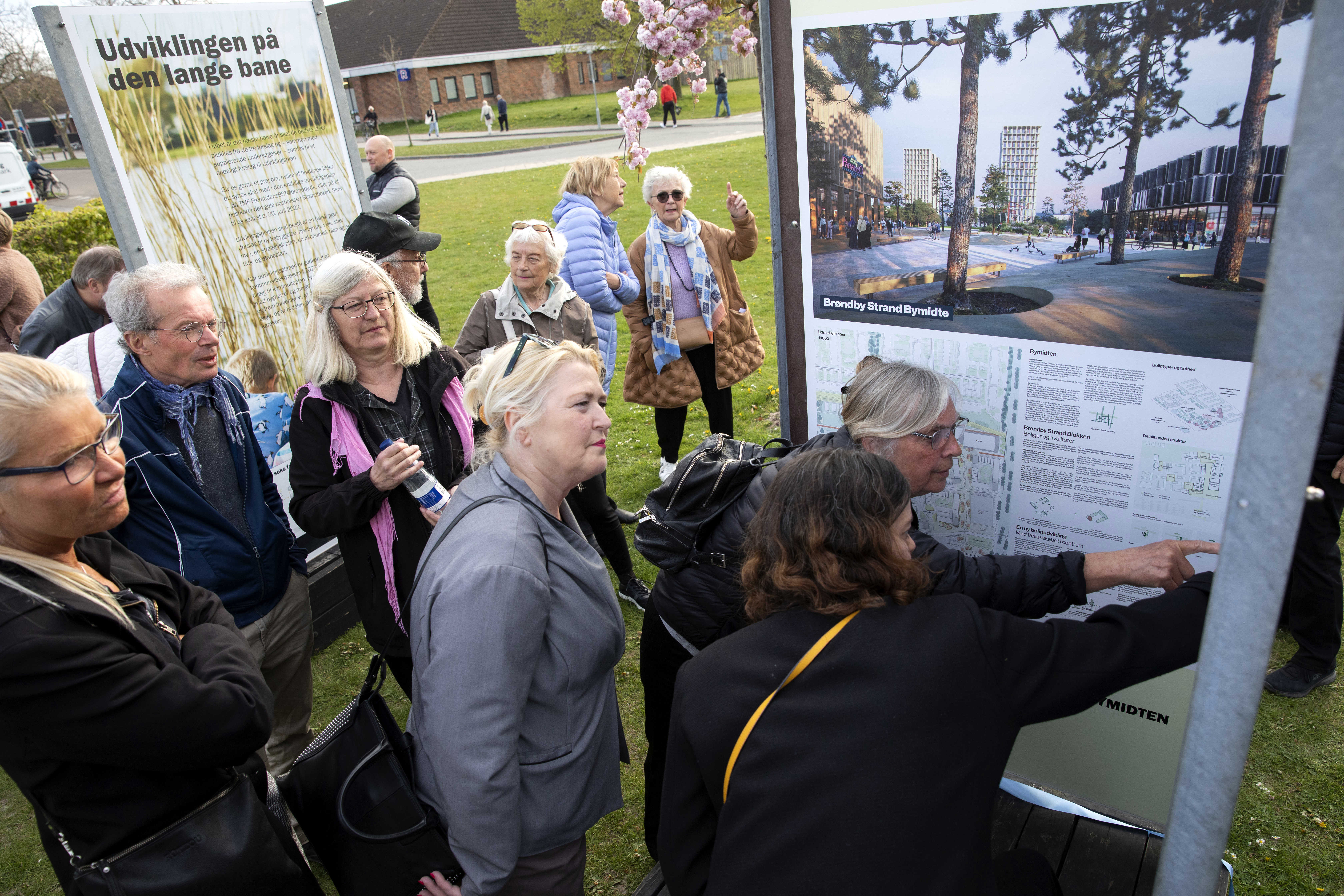 Borgere kigger og peger på plancher af forslag til udviklingsplanen