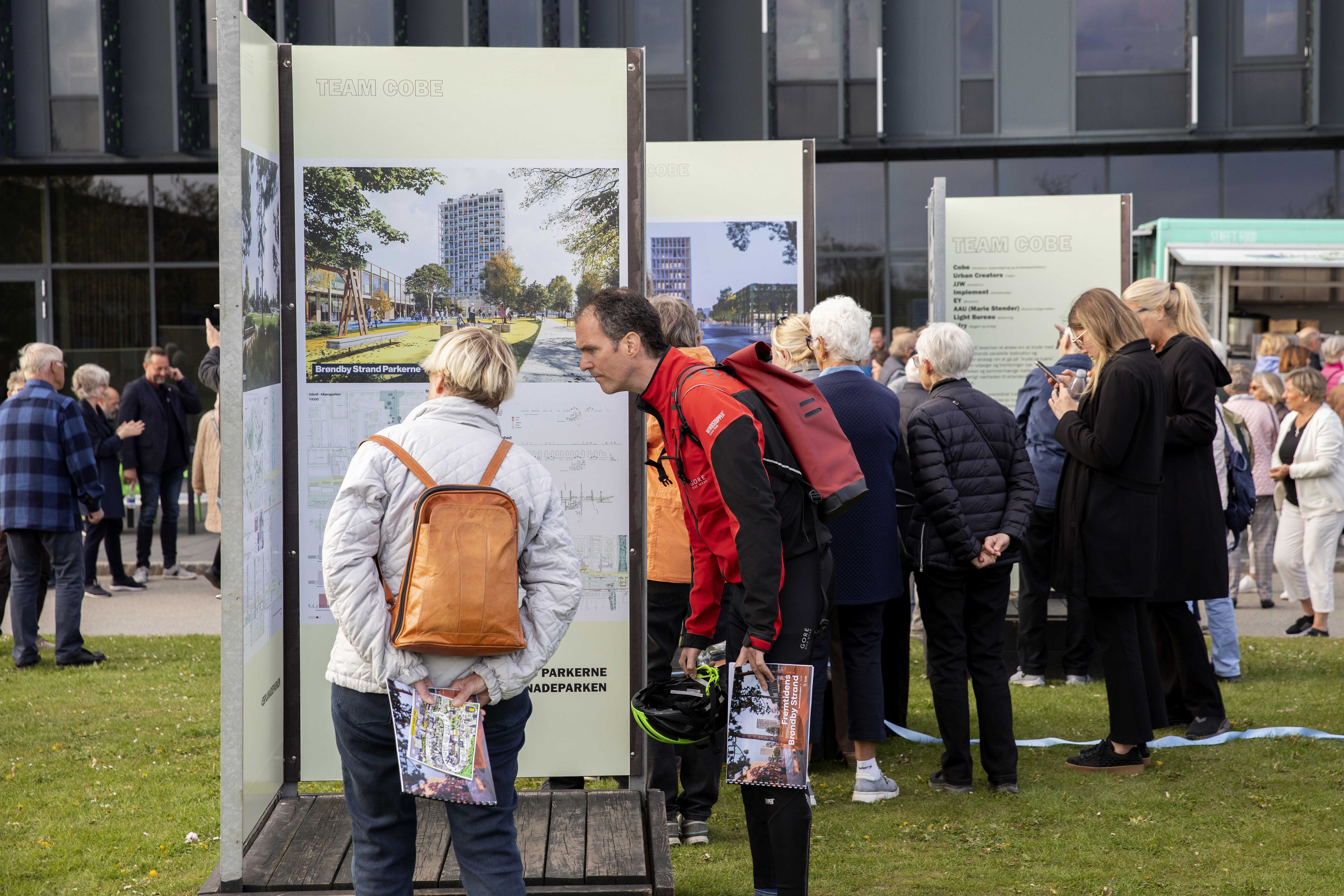 Borgere kigger og peger på plancher af forslag til udviklingsplanen